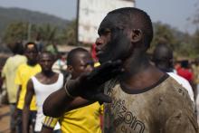 A man with charcoal smeared on his face reacts as a crowd barricades a street during a dispute between members of the local Christian community and ex-Seleka soldiers in Bangui