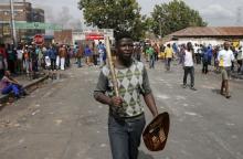 A local gestures as he holds a stick and a shield outside a hostel during anti-immigrant related violence in Johannesburg, April 17, 2015. PHOTO BY REUTERS/Siphiwe Sibeko