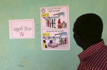 A man looks at a poster during registration for a Darfur referendum, on whether to remain as five states or merge into one, at a registration centre at Abo-Shouk IDPs camp at Al Fashir in North Darfur February 17, 2016. PHOTO BY REUTERS/Mohamed Nureldin Abdallah