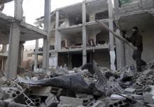 A man searches for belongings amid rubble of his damaged house in the Damascus suburbs of Arbeen, January 6, 2014. Picture taken