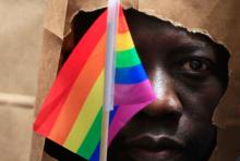 An asylum seeker from Uganda covers his face with a paper bag in order to protect his identity as he marches with the LGBT Asylum Support Task Force during the Gay Pride Parade in Boston, Massachusetts, June 8, 2013. PHTO BY REUTERS/Jessica Rinaldi