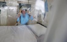 Matron Breda Athan demonstrates putting on the protective suit which would be used if it becomes necessary to treat patients suffering from Ebola