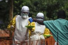 Medical staff working with Medecins sans Frontieres (MSF) prepare to bring food to patients kept in an isolation area at the MSF Ebola treatment centre in Kailahun, July 20, 2014. PHOTO BY REUTERS/Tommy Trenchard