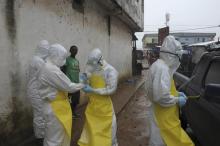 Health workers wearing protective clothing prepare before carrying an abandoned dead body presenting with Ebola symptoms at Duwala market in Monrovia, August 17 2014. PHOTO BY REUTERS/2Tango