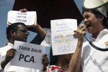 Members of non-government organisation (NGO) SUARAM (Suara Rakyat Malaysia) hold up placards during a protest against the new amendments in the Prevention of Crime Act (PCA)