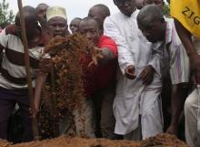 Men throw soil over the body of Zedi Feruzi, the head of opposition party UPD, during his funeral in Bujumbura, Burundi, May 24, 2015. PHOTO BY REUTERS/Goran Tomasevic