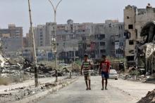 Men walk near destroyed buildings in Sabri, a central Benghazi district, Libya, August 12, 2017. PHOTO BY REUTERS/Esam Omran Al-Fetori