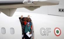 Migrants wave as they board a plane before being relocated to Sweden at Ciampino military airbase in Rome, Italy, October 9, 2015. PHOTO BY REUTERS/Remo Casilli