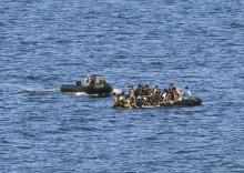 A dinghy with volunteer rescuers (L) approaches a dinghy with a broken engine overcrowded with Afghan refugees that drifted out of control between the Greek island of Lesbos and the Turkish coast, September 19, 2015. PHOTO BY REUTERS/Yannis Behrakis