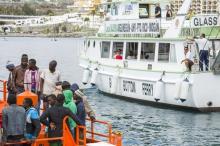 A tourist boat is next to a group of 45 migrants intercepted aboard a makeshift boat around 60 miles off the coast as their rescue boat arrives at Arguineguin port in the Canary Island of Gran Canaria, Spain, January 9, 2016. PHOTO BY REUTERS/Borja Suarez