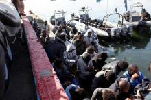 Migrants sit in a port, after being rescued at sea by Libyan coast guard, in Tripoli, Libya, April 11, 2016. PHOTO BY REUTERS/Ismail Zitouny