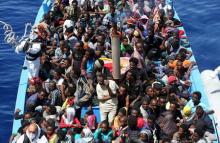 A group of 300 sub-Saharan Africans sit in board a boat during a rescue operation by the Italian Finance Police vessel Di Bartolo (not pictured) off the coast of Sicily, May 14, 2015. PHOTO BY REUTERS/Alessandro Bianchi