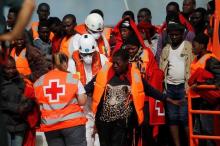 A migrant, who is part of a group intercepted aboard a dinghy off the coast in the Mediterranean sea, is helped by a member of Spanish Red Cross after arriving on a rescue boat at a port in Malaga, southern Spain, June 9, 2016. PHOTO BY REUTERS/Jon Nazca