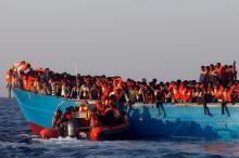 A rescue boat of the Spanish NGO Proactiva approaches an overcrowded wooden vessel with migrants from Eritrea, off the Libyan coast in Mediterranean Sea, August 29, 2016. PHOTO BY REUTERS/Giorgos Moutafis