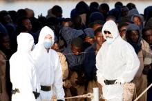 Migrants wait after disembarking from Spanish Navy cruiser Navarra in the Sicilian harbour of Catania, Italy, October 26, 2016. PHOTO BY REUTERS/Antonio Parrinello