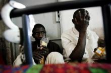 Two would-be immigrants of Mali sit inside a police station in the Mauritanian port city of Nouadhibou after being detained while trying to leave for Europe, March 14, 2006. PHOTO BY REUTERS/Juan Medina