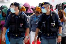 Migrants are escorted by Italian police officers after disembarking from Dignity ship in the Sicilian harbour of Augusta, Italy, October 19, 2016. PHOTO BY REUTERS/Antonio Parrinello