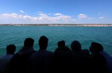 Migrants have a first glimpse of Europe aboard the former fishing trawler Golfo Azzurro, two days after they were rescued by the Spanish NGO Proactiva Open Arms in the central Mediterranean Sea, as they arrive at the port of Pozzallo in Sicily, March 30, 2017. PHOTO BY REUTERS/Yannis Behrakis