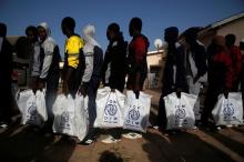 Gambian migrants who voluntarily returned from Libya stand in line with plastic bag from the International Organization for Migration (IOM) as they wait for registration at the airport in Banjul, Gambia April 4, 2017. PHOTO BY REUTERS/Luc Gnago