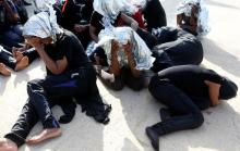 Migrants sit at a naval base after being rescued by Libyan coast guards in Tripoli, Libya, June 18, 2018. PHOTO BY REUTERS/Ismail Zitouny