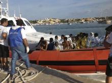 Rescued migrants arrive onboard a coastguard vessel at the harbour of Lampedusa, October 3, 2013. PHOTO BY REUTERS/Nino Randazzo