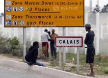 Migrants stand near a city sign along a road near the makeshift camp called "The New Jungle" in Calais, France, August 19, 2015. PHOTO BY REUTERS/Regis Duvignau