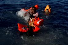 Migrants try to stay afloat after falling off their rubber dinghy during a rescue operation by the Malta-based NGO Migrant Offshore Aid Station (MOAS) ship in the central Mediterranean in international waters some 15 nautical miles off the coast of Zawiya in Libya, April 14, 2017. PHOTO BY REUTERS/Darrin Zammit Lupi