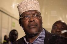 Miguna Miguna, a lawyer of dual Kenyan and Canadian citizenship, is seen through the glass door at the Jomo Kenyatta airport after he was detained by police in Nairobi, Kenya March 26, 2018, during an attempt to force him onto a plane to Canada, 2018. PHOTO BY REUTERS/Stephen Mdunga