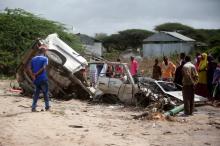 Residents gather to look at the wreckage of a minibus destroyed in roadside bomb in Lafoole village near Somalia's capital Mogadishu, June 30, 2016. PHOTO BY REUTERS/Feisal Omar