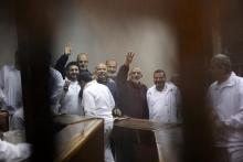 Muslim Brotherhood's Supreme Guide Mohamed Badie (3rd R) waves with the Rabaa sign, symbolizing support for the Muslim Brotherhood, with other brotherhood members at a court in the outskirts of Cairo, December 14, 2014. PHOTO BY REUTERS/Asmaa Waguih