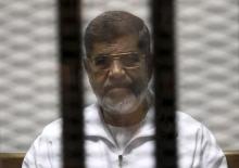 Ousted Egyptian President Mohamed Mursi is seen behind bars during his trial at a court in Cairo