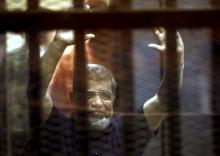 Former Egyptian President Mohamed Mursi reacts behind bars with other Muslim Brotherhood members at a court in the outskirts of Cairo, Egypt, May 16, 2015. PHOTO BY REUTERS/Mohamed Abd El Ghany