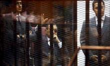 Egypt's former president Hosni Mubarak waves to his supporters with his sons Gamal (L) and Alaa (R) inside a cage in a courtroom during them trial at the police academy, on the outskirts of Cairo, May 9, 2015. An Egyptian court sentenced former president Mubarak and his two sons to three years in jail without parole on Saturday in the retrial of a corruption case. PHOTO BY REUTERS/Amr Abdallah Dalsh