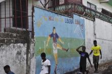 Men walk by a mural that reads "Get the hell of Liberia, Ebola! And don't come back" in Monrovia, Liberia, April 1, 2016. PHOTO BY REUTERS/James Giahyue