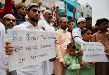 Muslims hold banners as they protest against the recent cases of mob lynching of Muslims who were accused of possessing beef, after offering Eid al-Fitr prayers in Ahmedabad, India, June 26, 2017. PHOTO BY REUTERS/Amit Dave