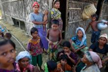 Rohingya Muslims pass time near their shelter at a refugee camp outside Sittwe