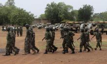 Soldiers from Lagos, part of an expected 1,000 reinforcements sent to Adamawa state to fight Boko Haram Islamists, walk near trucks as they arrive with the 23rd Armoured Brigade in Yola, May 20, 2013. PHOTO BY REUTERS/Stringer