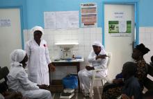 Nurses talk near a poster (C) displaying a government message against Ebola, at a maternity hospital in Abidjan