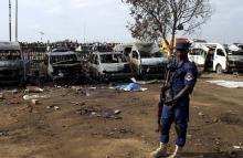 A paramilitary officer stands guard near damaged vehicles at the scene of a bomb explosion at Nyanyan, in Abuja