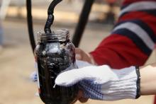 Oilfield workers collect a crude oil sample at an oil well operated by Venezuela's state oil company PDVSA, in the oil rich Orinoco belt, near Morichal at the state of Monagas, April 16, 2015. PHOTO BY REUTERS/Carlos Garcia Rawlins