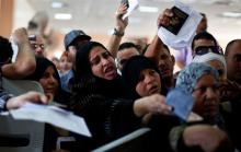 Passengers hoping to cross into Egypt show their passports to a Palestinian policeman at the Rafah crossing