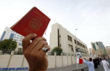 An anti-government protester holds up a Bahraini passport as he protests against nationalisation, in front of the Bahrain Immigration Directorate in Manama, March 9, 2011. PHOTO BY REUTERS/Hamad I Mohammed
