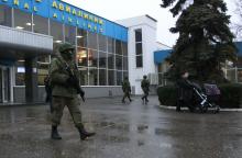 Armed men patrol at the airport in Simferopol, Crimea