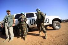 Peacekeepers stand guard near vehicles at the U.N. Compound in Nayala, South Darfur, November 30, 2010. PHOTO BY REUTERS/Mohamed Nureldin Abdallah