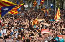 People react as they watch on giant screens a plenary session outside the Catalan regional parliament in Barcelona, Spain, October 27, 2017. PHOTO BY REUTERS/Yves Herman