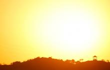 People are silhouetted against the setting sun at "El Mirador de la Alemana" (The viewpoint of the German), as the summer's second heatwave hits Spain, in Malaga, southern Spain, July 24, 2019. PHOTO BY REUTERS/Jon Nazca