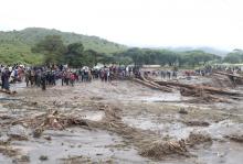 People stand near a bridge broken by heavy rains that caused landslides, in the village of Sebit, West Pokot County, Kenya, November 24, 2019. PHOTO BY REUTERS/Stringer