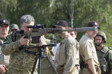 Ukraine's President Petro Poroshenko aims a rifle during his visit to a demonstration of new weapons for the Ukrainian armed forces at a military base outside Kiev