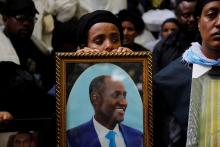 A mourner holds the photo of Amhara president Ambachew Mekonnen during a funeral ceremony in the town of Bahir Dar, Amhara region, Ethiopia, June 26, 2019. PHOTO BY REUTERS/Baz Ratner