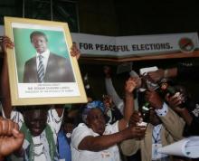 Patriotic Front General Secretary Davies Chama (L) celebrates while holding a portrait of President Edgar Chagwa Lungu after Lungu narrowly won re-election on Monday in the capital, Lusaka, Zambia, August 15, 2016. PHOTO BY REUTERS/Jean Serge Mandela